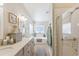 Bright bathroom featuring double sinks, a soaking tub, and a walk-in shower with a glass door at 18051 E Happy Rd, Queen Creek, AZ 85142