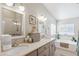 Bright bathroom featuring double sinks, a soaking tub, and a walk-in shower with a glass door at 18051 E Happy Rd, Queen Creek, AZ 85142