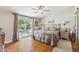 Tranquil bedroom with warm wood floors, ceiling fan, sliding glass door to patio, and natural light at 18051 E Happy Rd, Queen Creek, AZ 85142