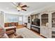 Bright living room featuring built-in cabinets, a ceiling fan, and wood flooring, creating a warm atmosphere at 18051 E Happy Rd, Queen Creek, AZ 85142