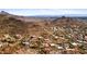 Stunning aerial view showcases desert homes nestled amidst mountains and distant city skyline at 1836 E Turquoise Ave, Phoenix, AZ 85020