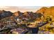 Stunning aerial view of desert homes nestled in mountains with paved roads and vibrant landscaping at sunset at 1836 E Turquoise Ave, Phoenix, AZ 85020