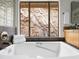 A well-lit bathroom features a bathtub, a shower with glass block and a scenic view at 1836 E Turquoise Ave, Phoenix, AZ 85020