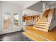 Bright entryway features a wood staircase, tile floor, and views into the living room at 1836 E Turquoise Ave, Phoenix, AZ 85020
