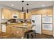 Well-equipped kitchen featuring custom wood cabinets, island seating, and modern fixtures at 1836 E Turquoise Ave, Phoenix, AZ 85020