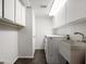 Well-lit laundry room with white cabinets, sink, and modern washer and dryer at 1836 E Turquoise Ave, Phoenix, AZ 85020