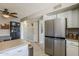 Open kitchen with white cabinets, stainless steel refrigerator, and tile flooring at 1838 E 2Nd Pl, Mesa, AZ 85203