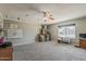 Bright, carpeted living room with ceiling fan, a desk under the window, and storage at 1838 E 2Nd Pl, Mesa, AZ 85203
