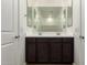 Double sink vanity with dark wood cabinets and a large mirror at 18418 W Monte Lindo Ln, Surprise, AZ 85387