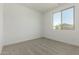 This bedroom features neutral carpet and a large window for plenty of natural light at 18418 W Monte Lindo Ln, Surprise, AZ 85387