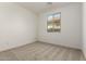 This bedroom features neutral carpet and a window with a view of the exterior at 18418 W Monte Lindo Ln, Surprise, AZ 85387