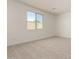 This bedroom features neutral carpet and a window with a backyard view at 18418 W Monte Lindo Ln, Surprise, AZ 85387