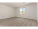 This bedroom features neutral carpet and a window with a backyard view at 18418 W Monte Lindo Ln, Surprise, AZ 85387