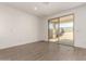Light and airy bedroom showcasing tile floors, a patio door, and a neutral color palette at 18418 W Monte Lindo Ln, Surprise, AZ 85387
