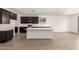 Modern kitchen with a large island, dark cabinets, and stainless steel appliances at 18418 W Monte Lindo Ln, Surprise, AZ 85387