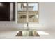 Modern kitchen sink with white countertops and view to the outside at 18418 W Monte Lindo Ln, Surprise, AZ 85387