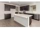 Well-equipped kitchen featuring dark wood cabinets, and a functional island with plenty of counter space at 18418 W Monte Lindo Ln, Surprise, AZ 85387