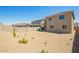 A wide backyard showing a covered patio, gravel, small grass, and block fence at 18456 W Monte Lindo Ln, Surprise, AZ 85387