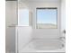 Bright bathroom featuring a soaking tub with a view from the large window and a glass shower at 18456 W Monte Lindo Ln, Surprise, AZ 85387
