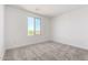 Bedroom with neutral carpet, white walls, and a window providing natural light at 18456 W Monte Lindo Ln, Surprise, AZ 85387