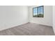 Bedroom with neutral carpet, white walls, base trim, and a window providing natural light at 18456 W Monte Lindo Ln, Surprise, AZ 85387