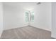 A bright bedroom with neutral carpet and two windows offering natural light at 18456 W Monte Lindo Ln, Surprise, AZ 85387