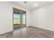 Light-filled bedroom featuring wood look tile floors and access to a private outdoor space at 18456 W Monte Lindo Ln, Surprise, AZ 85387