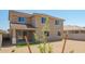 Beautifully built home with a covered patio, green turf, a desert rock yard, and mature trees at 18456 W Monte Lindo Ln, Surprise, AZ 85387