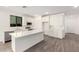 Bright kitchen featuring white cabinets, stainless steel appliances, and a spacious center island with quartz countertops at 18456 W Monte Lindo Ln, Surprise, AZ 85387