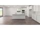 Bright kitchen featuring white cabinets, stainless steel appliances, and a spacious center island with quartz countertops at 18456 W Monte Lindo Ln, Surprise, AZ 85387