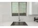 Close up of the stainless steel kitchen sink, white quartz counters, and white herringbone backsplash at 18456 W Monte Lindo Ln, Surprise, AZ 85387