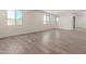 Expansive living room showcases wood look tile floors, natural light, and a modern, minimalist design at 18456 W Monte Lindo Ln, Surprise, AZ 85387
