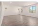 Bright, spacious living room featuring wood look tile floors, modern lighting, and large windows at 18456 W Monte Lindo Ln, Surprise, AZ 85387