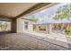 Covered patio and a paver patio look out on landscaped backyard and stone fireplace at 18624 W Cathedral Rock Dr, Goodyear, AZ 85338