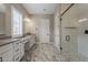 Bright bathroom featuring a glass shower, double vanity sinks, and stylish marble floors at 18624 W Cathedral Rock Dr, Goodyear, AZ 85338
