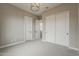 Neutral bedroom featuring light gray walls and trim, neutral carpeting, and bright-white closet and passage doors at 18624 W Cathedral Rock Dr, Goodyear, AZ 85338