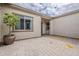 Open-air courtyard with tiled floor and tan stucco walls and potted plants at 18624 W Cathedral Rock Dr, Goodyear, AZ 85338
