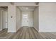 Inviting entryway with wood floors, a white front door, and white brick accent wall at 18624 W Cathedral Rock Dr, Goodyear, AZ 85338