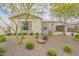 Charming home exterior featuring desert landscaping with stone accents and mature trees at 18624 W Cathedral Rock Dr, Goodyear, AZ 85338