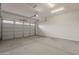 Clean, modern garage with a roll-up door, concrete floor, and bright lighting at 18624 W Cathedral Rock Dr, Goodyear, AZ 85338