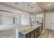Modern kitchen with large island, stainless steel appliances, white brick wall, and wooden beam accents at 18624 W Cathedral Rock Dr, Goodyear, AZ 85338