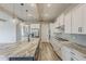 Modern kitchen featuring stainless steel appliances, gray subway tile, marble countertop, and wooden beam accents at 18624 W Cathedral Rock Dr, Goodyear, AZ 85338