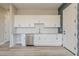 Kitchenette area with white cabinets, stainless steel appliances, white backsplash, hard surface flooring and door at 18624 W Cathedral Rock Dr, Goodyear, AZ 85338