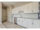 Kitchenette area with white cabinets, stainless steel appliances, white backsplash, hard surface flooring and door at 18624 W Cathedral Rock Dr, Goodyear, AZ 85338