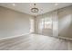 Bright living room features stylish light fixture, wood floor, and backyard access at 18624 W Cathedral Rock Dr, Goodyear, AZ 85338