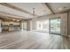 Open-concept living room with kitchen and dining space features hardwood floors and sliding doors to outdoor patio at 18624 W Cathedral Rock Dr, Goodyear, AZ 85338
