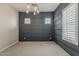 Living room with gray-blue walls, neutral carpet, a modern chandelier and windows with shutters at 18624 W Cathedral Rock Dr, Goodyear, AZ 85338