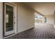 Covered patio features brick flooring, textured walls and entry to backyard at 18624 W Cathedral Rock Dr, Goodyear, AZ 85338