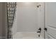 Bathtub shower combo featuring white herringbone tile, matte black plumbing fixtures and a decorative shower curtain at 18624 W Cathedral Rock Dr, Goodyear, AZ 85338