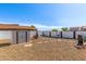 Wide backyard view featuring a storage shed, gravel ground cover, firepit area, and perimeter privacy fencing at 1950 E Dust Devil Dr, San Tan Valley, AZ 85143
